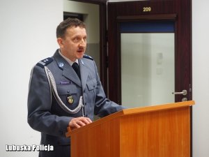 Młodszy Inspektor Mirosław Kędziora wygłasza przemówienie okolicznościowe stojąc przy mównicy.