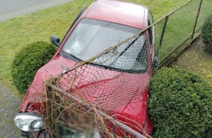 Pojazd po wypadku, wbity w przęsła ogrodzenia posesji.